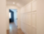 Modern white hallway with built-in storage cabinets.