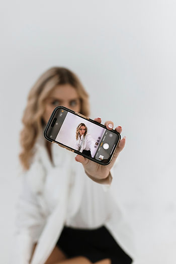 A girl taking a selfie using an iPhone