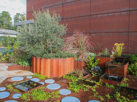 another view of the courtyard at pulp featuring the cube shaped water fountains, large scale metal planters and terrazzo stepping stones
