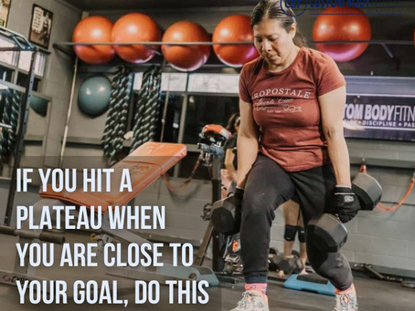 Women lifting weights overhead in a gym; bold text reads THIS MAYBE THE BIGGEST CAUSE OF YOUR PLATEAU.