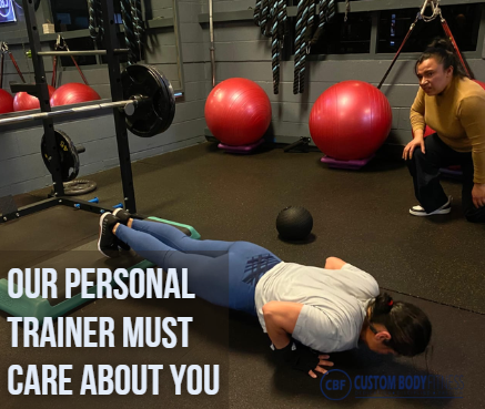 Woman doing push-ups in a gym, observed by a trainer. Background features red exercise balls. Text: "Our personal trainer must care about you."
