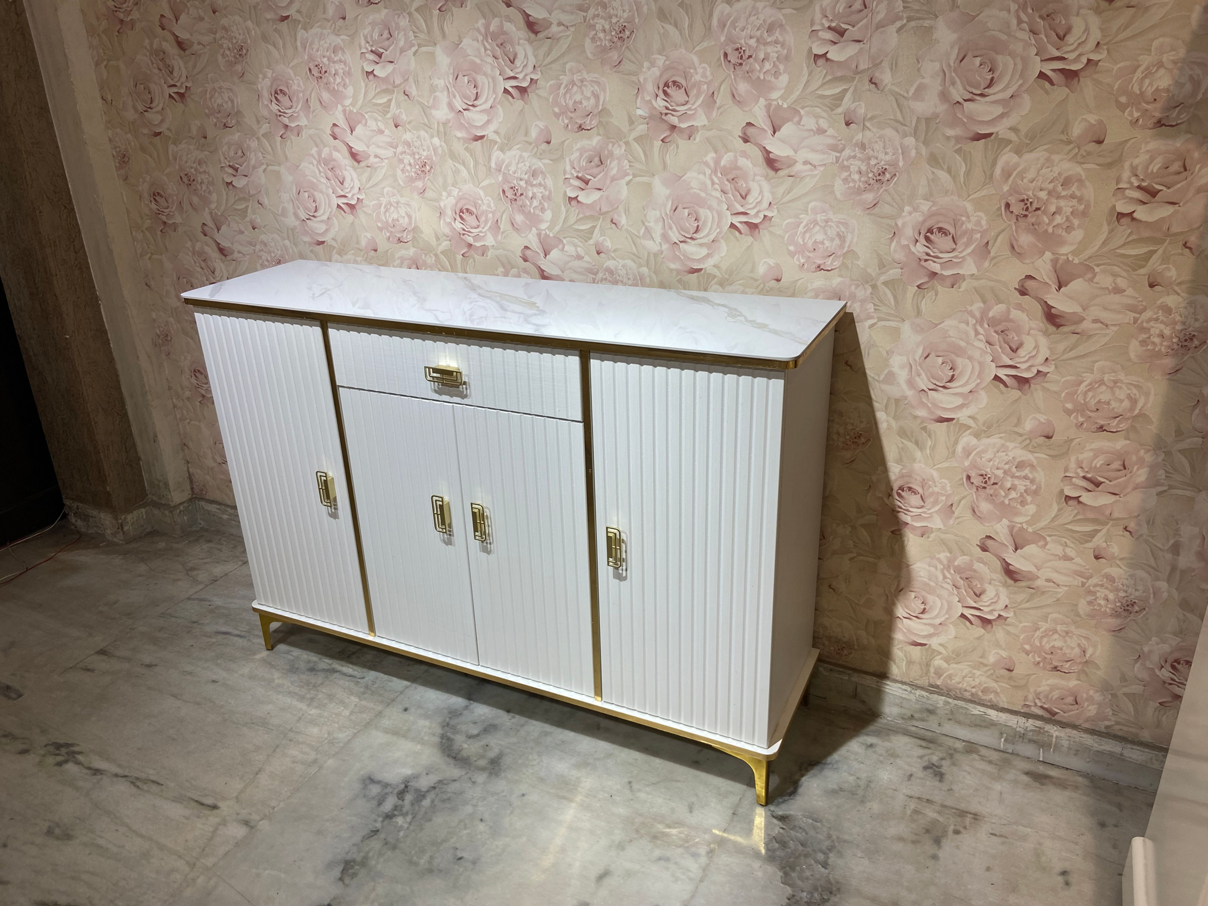 4-Feet cabinet in a pristine white matte finish with a glass top & golden strip