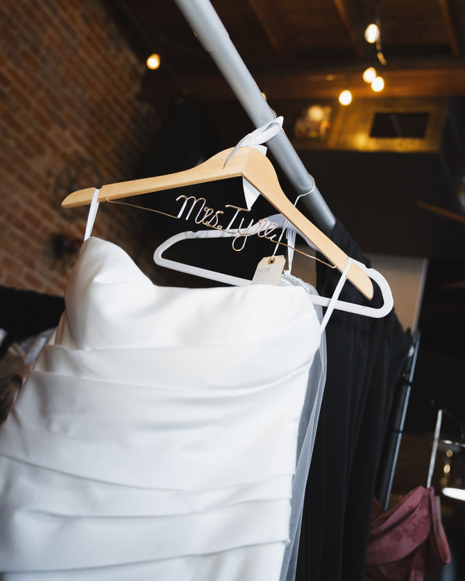 A beautiful wedding dress hanging on a hanger at the Lumberyard Huntsville Wedding Venue
