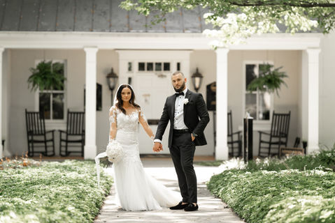 Bride and groom holding hands together and posing for a wedding photo