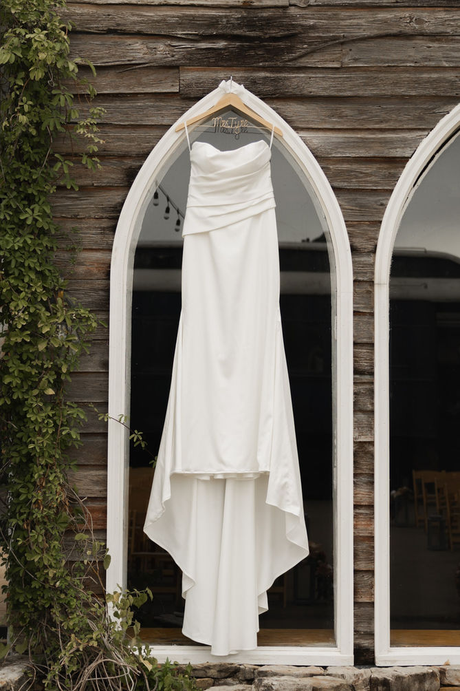 A beautiful wedding dress hanging on a hanger at the Lumberyard Huntsville Wedding Venue

