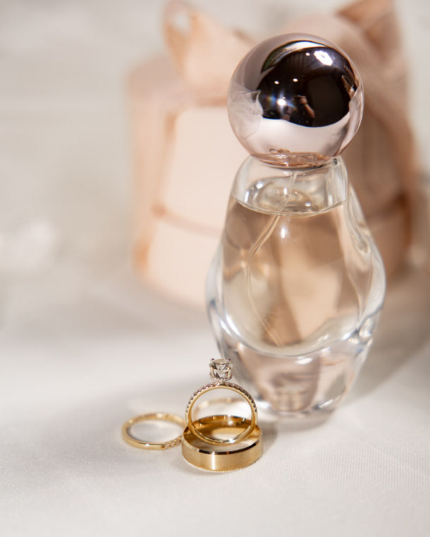 close-up of bride's intricate wedding shoes and ring on a white floor
