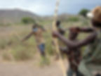 Hadza archers demonstrate bow skills near Lake Eyasi, Tanzania. What visitors observe depends on the day, and neither wildlife encounters nor a successful hunt should ever be treated as guaranteed entertainment. Photo: Woodlouse/Wikimedia Commons, licensed under CC BY-SA 2.0.