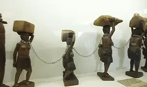 Wooden figures of enslaved Africans bound in chains, a haunting display at Luanda’s National Museum of Slavery.