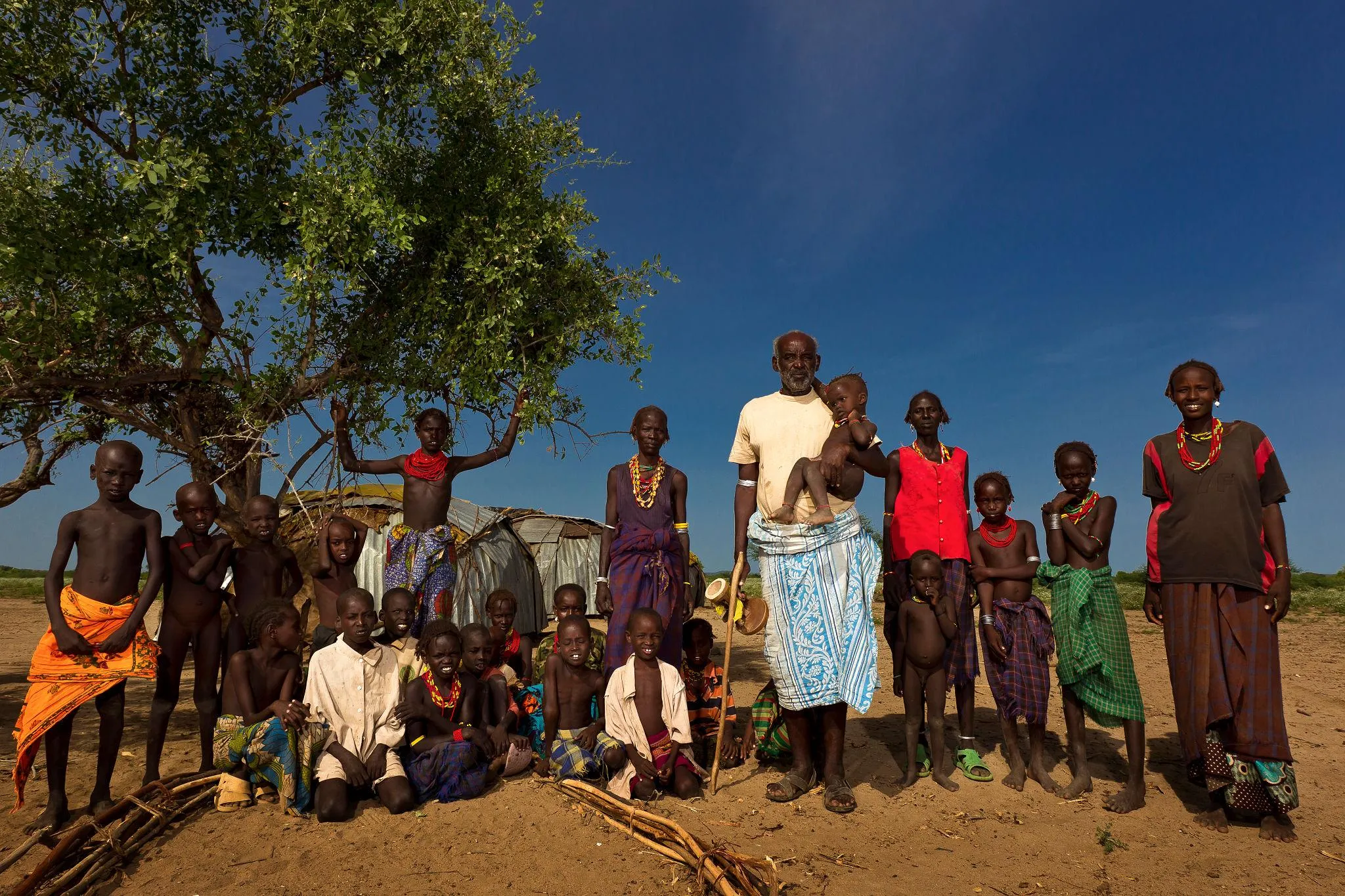 A Daasanach pastoralist stands with members of his extended family near Lake Turkana