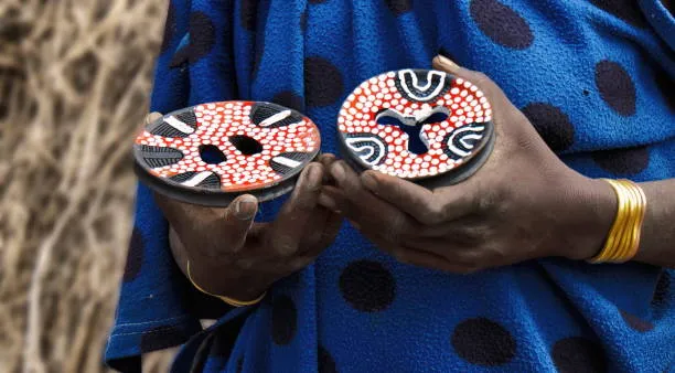 Handcrafted Suri lip plates decorated with intricate red, white, and black geometric patterns