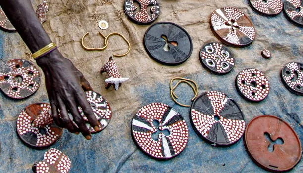 Handcrafted Suri lip plates decorated with intricate red, white, and black geometric patterns