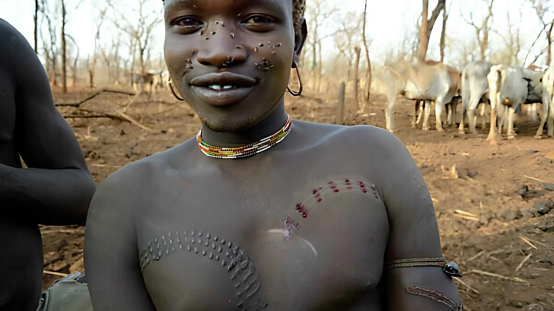 A young man displays fresh cuts and healed raised scars across her chest, showing different stages