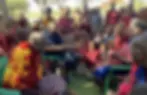 Maasai elders gather with children and community members during a local meeting, illustrating the central role of elders in preserving cultural traditions, guiding community decisions, and passing knowledge to younger generations.
