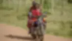 Maasai men ride a motorcycle along a rural road, illustrating how modern transport has become part of everyday life while traditional dress and cultural identity remain proudly preserved.