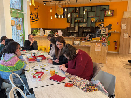 Groupe de personnes âgées et une bénévole jouant à un jeu de société