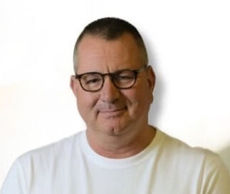 תמונת פרופיל של ניצן פלג,תמונה המציגה את ראשו וכתפיו, לובש משקפי ראייה עם מסגרת שחורה וחולצה לבנה