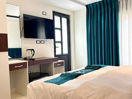 Television, kettle and double bed in Palm room Villa Maria Lodge Petra Jordan