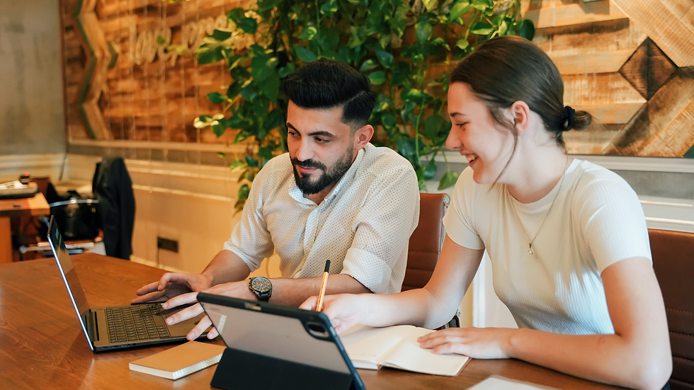 A man and woman looking at screens in a fresh, plant-filled office