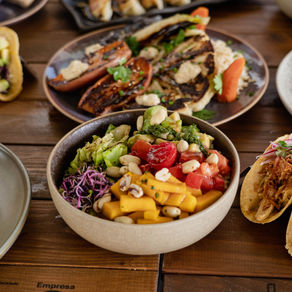 Mesa con platos vegetarianos, veganos y no veggies en All You Eat Is Love, Poblenou