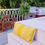 थंबनेल: "Nature-inspired mustard yellow bird trail cushion for interior design"
