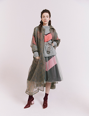 a patterned organza coat tops a tulle dress, leather skirt, and knit sweater