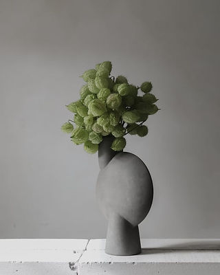 floral arrangement in tall gray ceramic vase