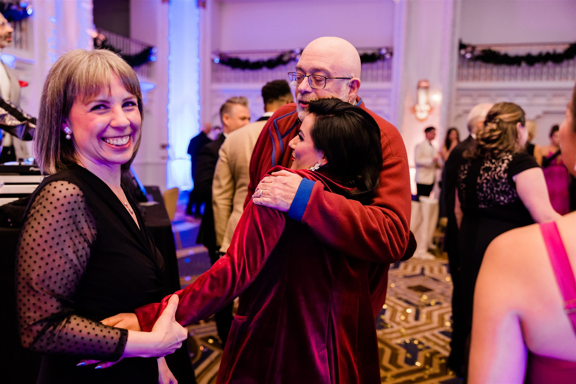people hugging and celebrating at a formal gala party