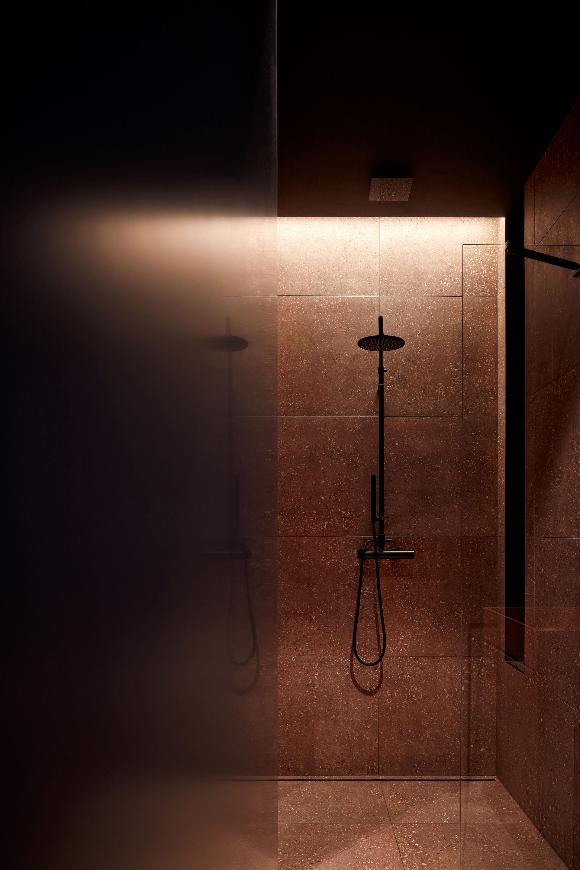 a luxury show in dark moody color palette of browns and black with large format tiles