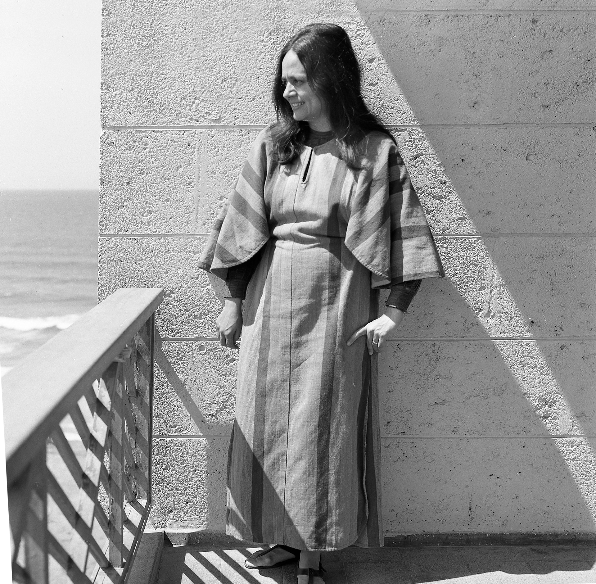 portrait of architect Tamar de Shalit on balcony overlooking beach