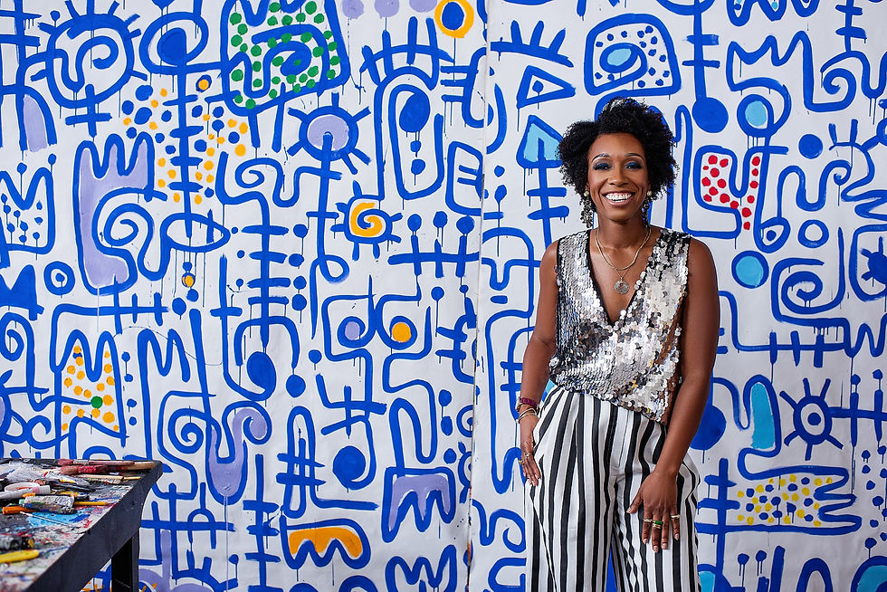 glamorous designer standing in front of painting, wearing sequin vest, striped pants