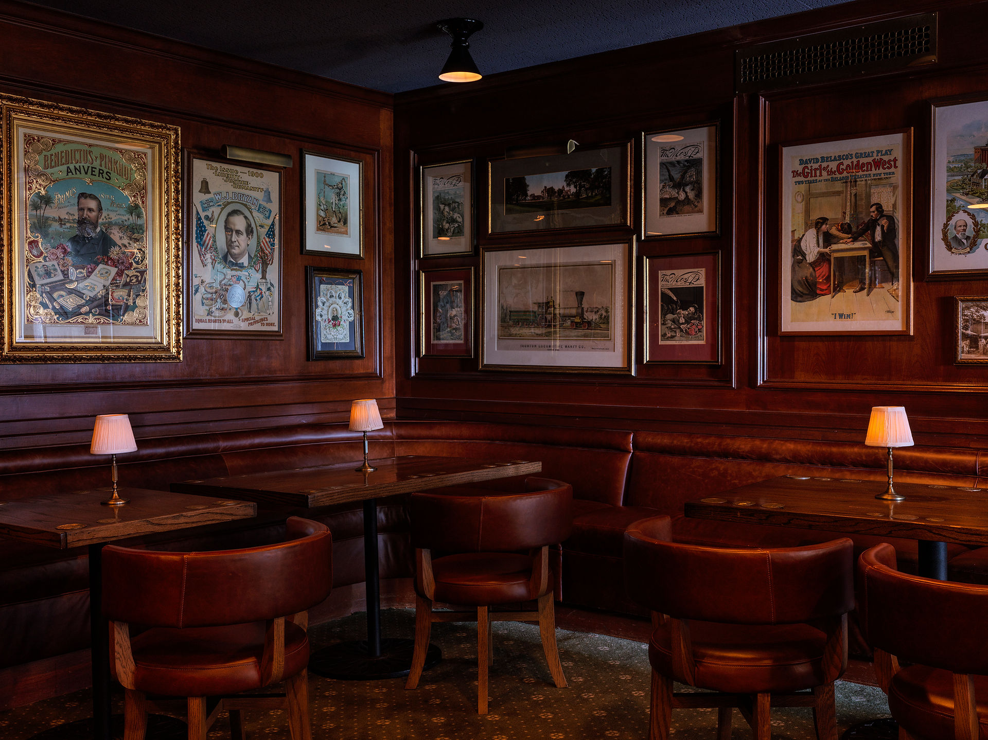 vintage bar tables and chairs with gallery wall of framed portraits