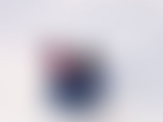 Person im bunten Winteroutfit rutscht auf blauem Snowtube durch eine weiße Schneelandschaft