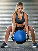 Sporty Woman Lifting a Medicine Ball 