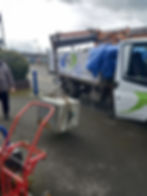 Lorry crane lifting a heavy concrete block during waste collection