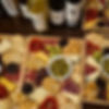 wooden trays full of cheese biscuits and charcuterie and bottles of wine