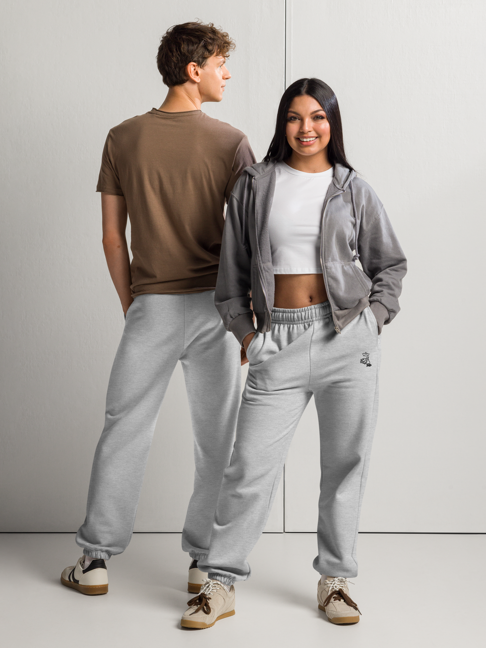 couple homme-femme posant dans le même pantalon jogger molleton gris chiné brodé logo Mascotte noir sous poche gauche