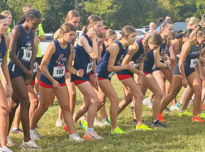 Women's varsity race preparing at the starting line.