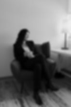 Woman in a suit sitting in an armchair, looking right