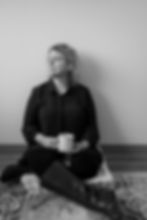 Woman sitting, holding mug, looking away