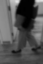 Person walking quickly with a bag