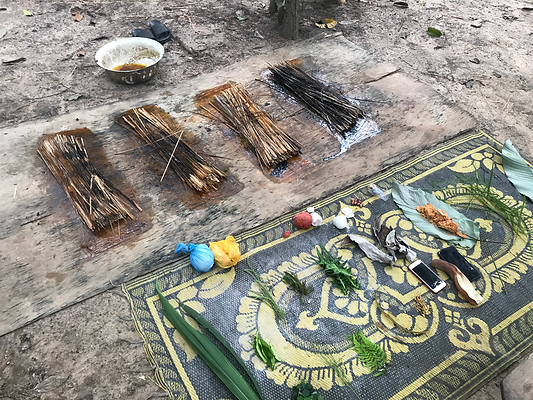 Preparing items on a mat outdoors, with sticks and other materials Journey In