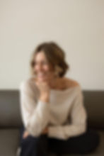 Smiling woman with short hair, resting chin on hand