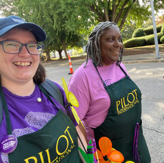 Two women in green Pilot International aprons walking outside