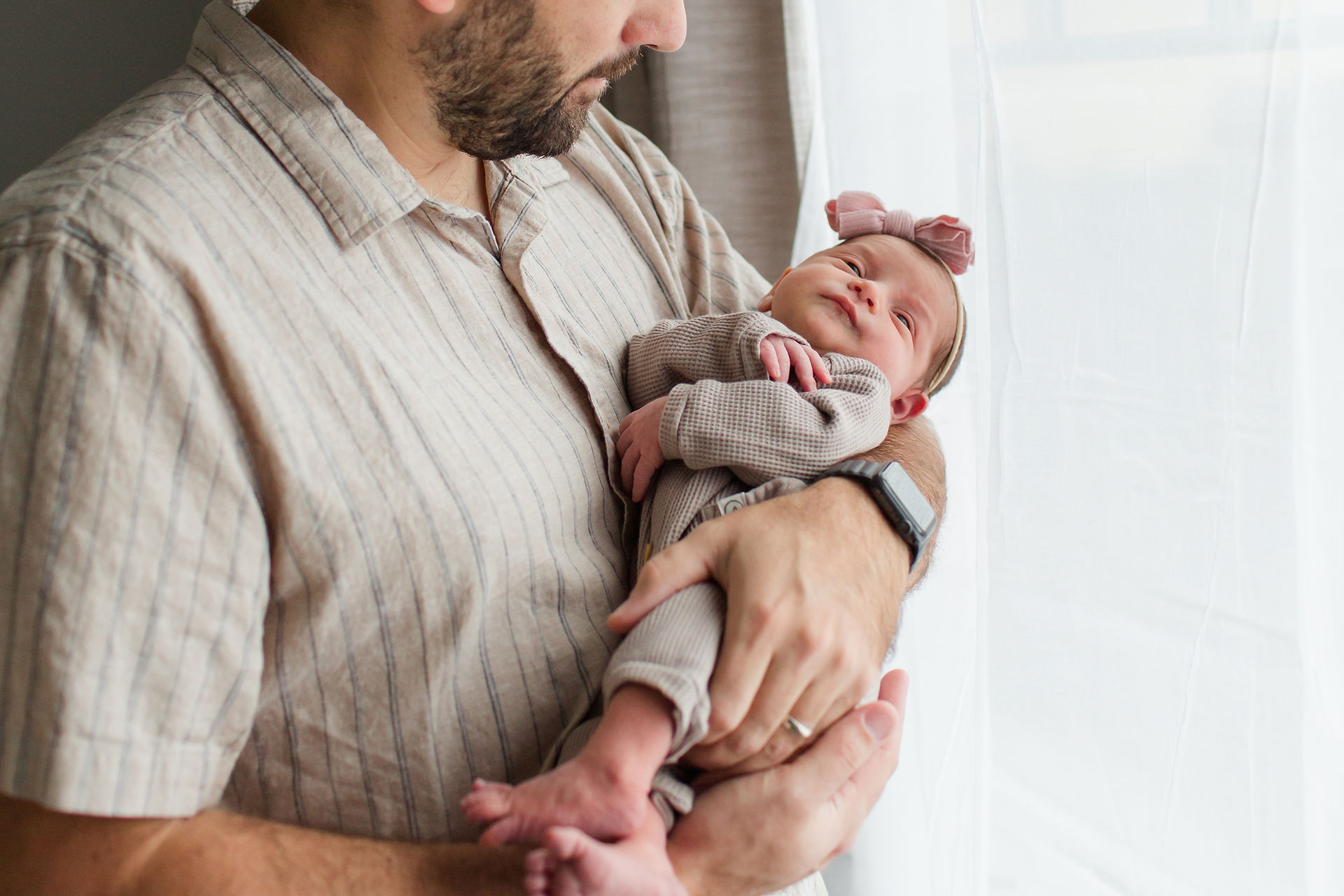 hk create photography bay area newborn photographers family lifestyle session in bedroom dad holding baby girl neutral outfits