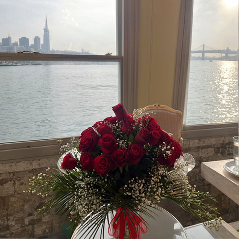 Kırmızı güller buketi, şehir manzarası ve köprü, iç mekanda, gün batımı.