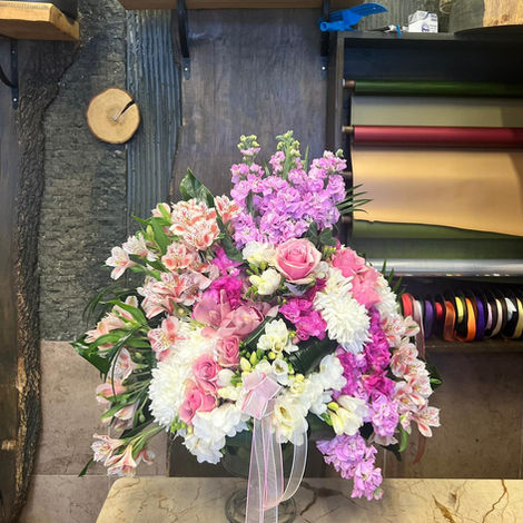 Vazoda pembe, beyaz ve mor çiçeklerle dolu bir buket, Koleksiyonlar ahşap tezgahta