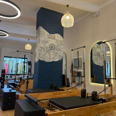 Pilates stüdyosunda egzersiz ekipmanları ve modern tasarım, aydınlatma detayları ile.