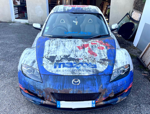 Mazda RX8 en full wrap texturé sortie de grange avec une livrée au style IMSA des 80's. Un design Graphikustoms.