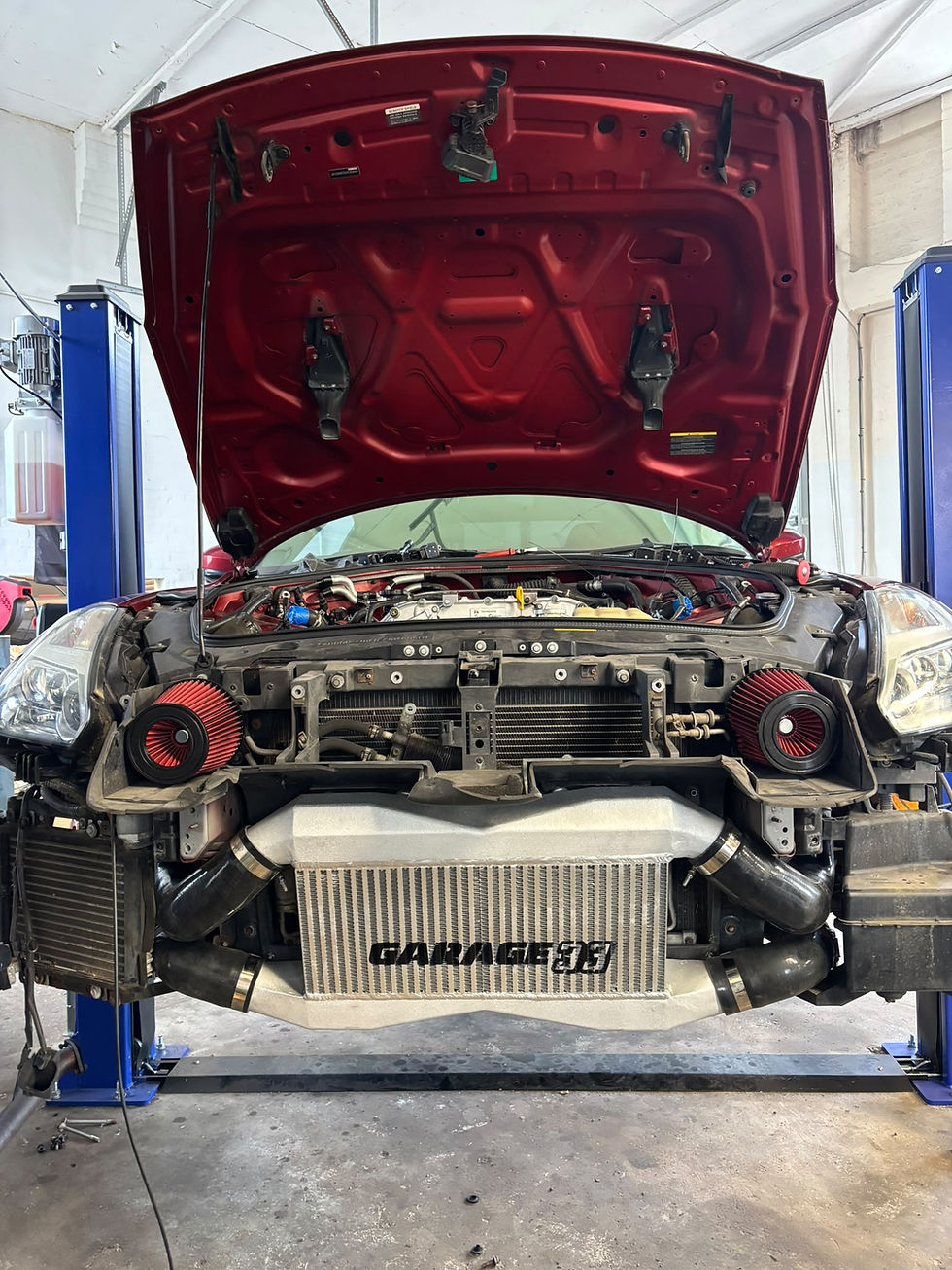 Japanese automotive repair on a car engine with open hood