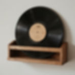 Black vinyl record displayed upright in a wooden holder